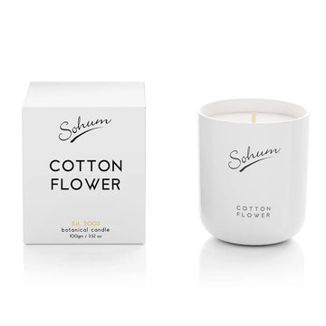 A white candle next to a matching white box with the text 'Sohum Cotton Flower' written on both items.