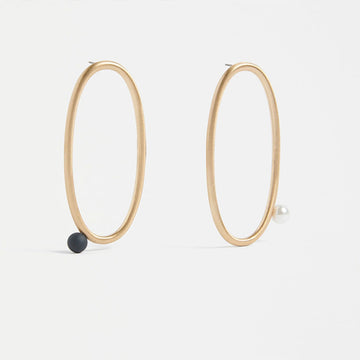 An image of earrings that are a large Gold metallic oval with a one bead placement.