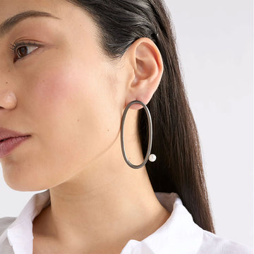 An image of earrings that are a large Gold metallic oval with a one bead placement.