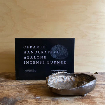 Ceramic handcrafted abalone incense burner with packaging on a wooden surface.