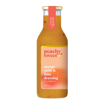 A bottle filled with an orange coloured dressing and a product label with the text 'Peachy Sweet Mango Chilli and Lime Dressing'.