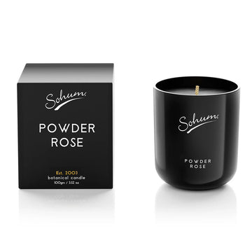 A black candle next to a matching black box with the text 'Sohum Powder Rose' written on both items.