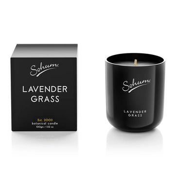 A black candle next to a matching black box with the text 'Sohum Lavender Grass' written on both items.