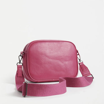 Front view of a cross body bag in fuchsia leather.
