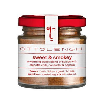 A jar filled with spices and a white label on the front with the text 'Sweet and Smokey a warming sweet blend of spices with chipotle chilli, coriander and paprika'.