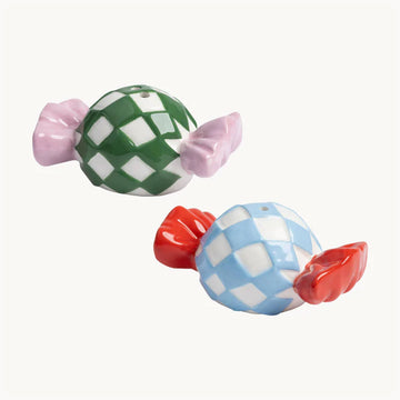 Two ceramic salt and pepper shakers shaped like wrapped up candy.