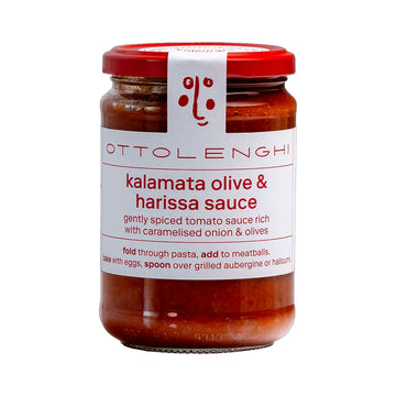 A jar filled with tomato sauce and a white label on the front with the text 'Kalamata Olive & Harissa Sauce'.