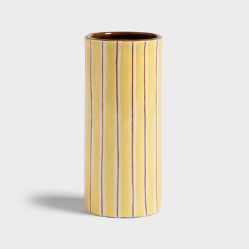 Cylindrical ceramic vase with vertical stripes on a light gray background.