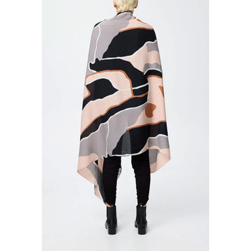 A silk scarf in light pink, grey and brown is half folded up and half floating.