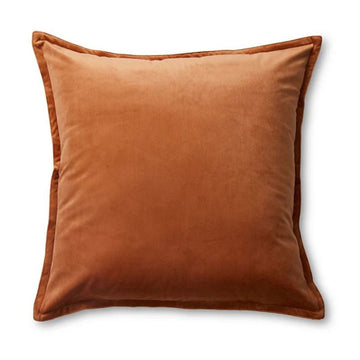 A square velvet cushion in a rust brown colour.