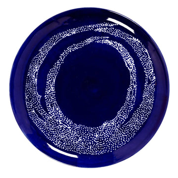 Top down view of a blue plate with a white dot design.