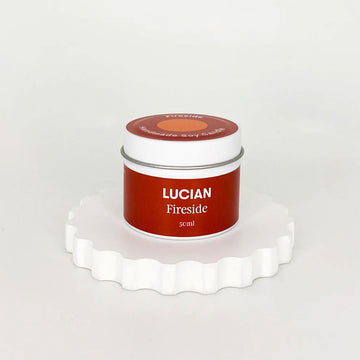A closed tin with a red label and the text 'Lucian Fireside' on a white scalloped surface.