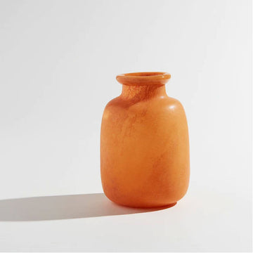 A tall round vase in the shape of a jar with a smaller opening in an orange colour.
