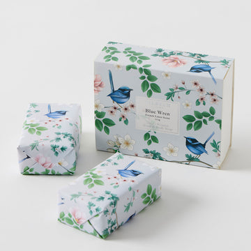 Two wrapped soaps next to a matching box printed with flowers and blue wren birds.