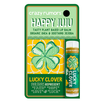 A tube of lip balm attached to a card with the heading 'Happy Juju' and an illustration of a four leaf clover.