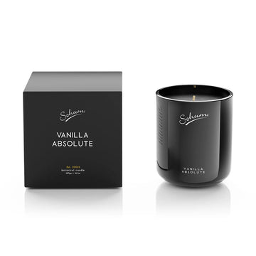 A black glass candle next to a matching black cube box with the text 'Vanilla Absolute' on the front.