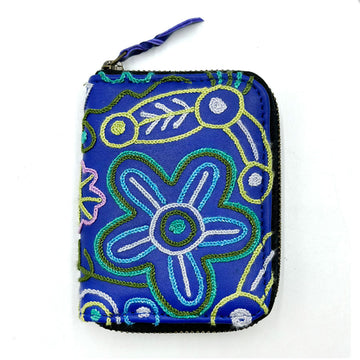 A zippered purse in blue embroidered with artwork by Cedric Varcoe.