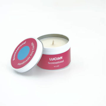 A candle in a small tin with a red pink label and the text 'Lucian Scentsational' on the side.