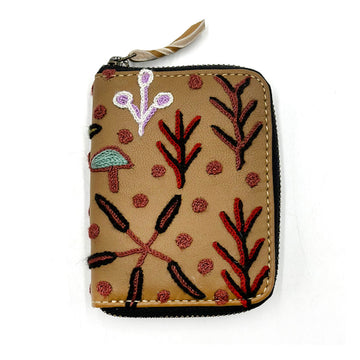 A zippered purse in brown embroidered with artwork by Betty Pula Morton.