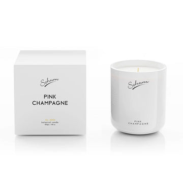 A white glass candle next to a matching white cube box with the text 'Pink Champagne' on the front.