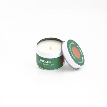 A candle in a small tin with a green label around the edge with the text 'Lucian O'live, laugh, love'.