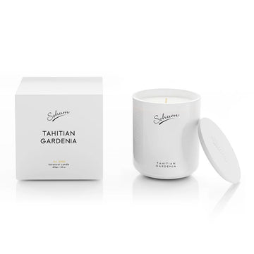 A white glass candle next to a matching white cube box with the text 'Tahitian Gardenia' on the front.