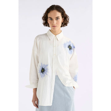 White shirt with blue floral embroidery on a white background.
