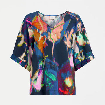 Colorful abstract patterned top on a white background.