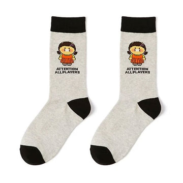 Two socks with cartoon character and text 'Attention All Players' on a white background.