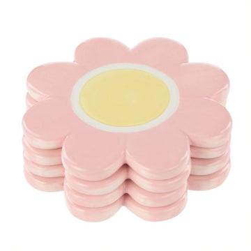 An image of four pink and yellow flower shaped coasters stacked on each other.