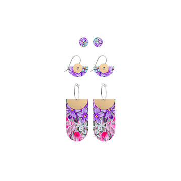Three pairs of earrings each printed with purple floral artwork. There is a pair of circle studs, semi circle drops and tab shapes attached to hoops.