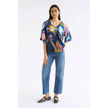 Colorful abstract patterned top on a white background.