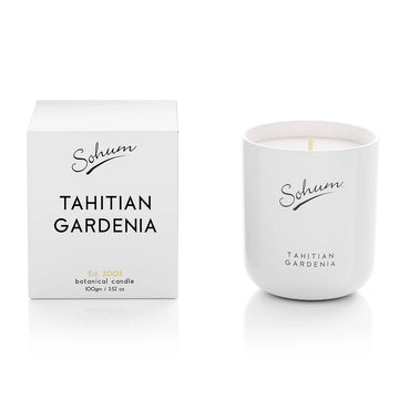 A white glass candle next to a matching white cube box with the text 'Tahitian Gardenia' on the front.
