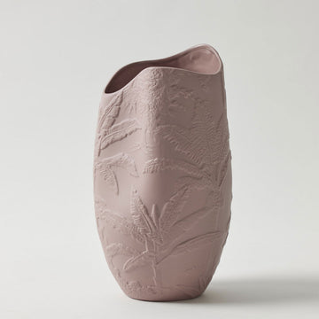 A porcelain vase in a dusty pink colour embossed with flowers.