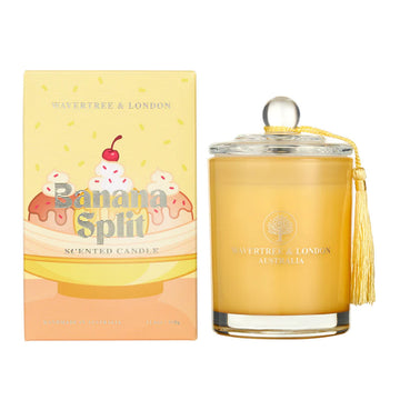 A yellow glass candle next to a box. The box has the text 'Banana Split' over an illustrated banana split sundae.