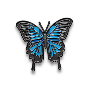 Blue butterfly-shaped enamel pin on a white background.