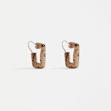 Pair of bronze speckled square hoop earrings on a white background.