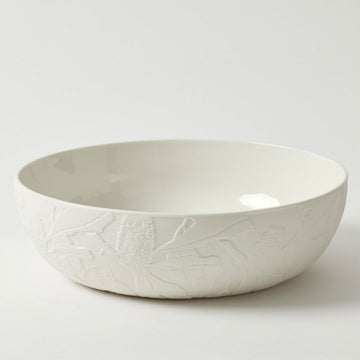 A white porcelain bowl embossed with flowers around the outside.