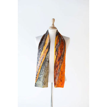 A silk scarf is draped over the shoulders of a mannequin. The scarf is printed with artwork in shades of brown and orange.