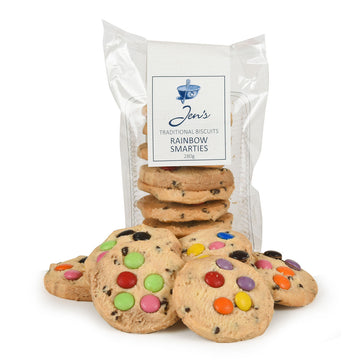 A clear packet filled with cookies and a few cookies in front of the packet decorated with smarties.