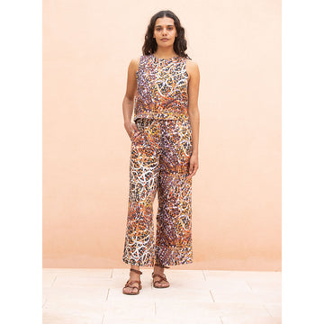 Front view of a woman wearing a patterned outfit against a peach background.