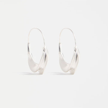 Silver hoop abstract earrings on a light grey background.