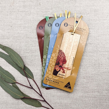 Set of wooden bookmarks with a natural design on a textured surface.