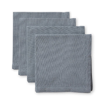 Set of four folded blue-gray napkins on a white background.