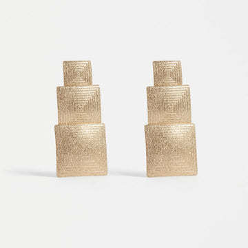A pair of earrings featuring three different sized gold squares.