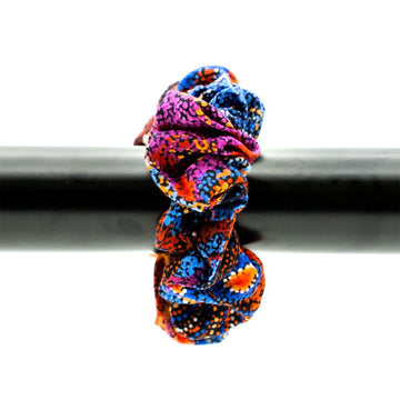 A scrunchie printed with colourful artwork attached to a black bar.