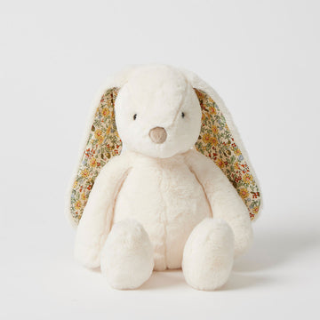 A white bunny soft toy with floral inner ears in a sitting pose.