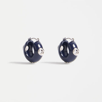 Pair of navy blue hoop earrings with silver accents on a light gray background