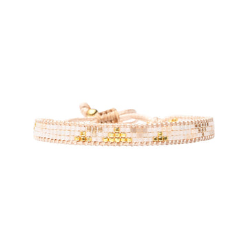 Beaded bracelet in gold and beige on a white background.