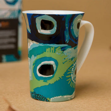 A ceramic mug printed with artwork by May Wokka.